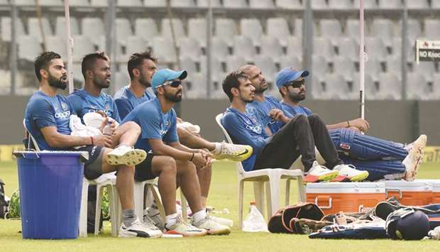 Indian players (from left) Virat Kohli, Hardik Pandya, Axar Patel, Ajinkya Rahane, Yuzvendra Chahal, Shikhar Dhawan and Rohit Sharma watch as their teammates take part in a training session at the Wankhede stadium in Mumbai, ahead of the first ODI against New Zealand, yesterday. (AFP)