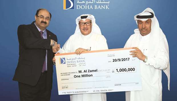 Doha Bank officials with one of the latest winners of the banku2019s Al Dana Savings Scheme campaign for September 2017.