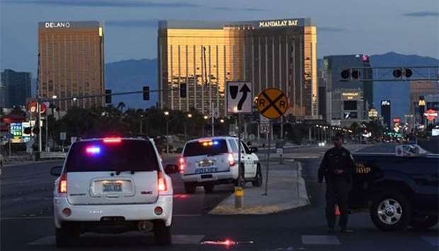 Police form a perimeter around the road leading to the Mandalay Hotel (background) after a gunman killed at least 50 people and wounded more than 400 others when he opened fire on a country music concert in Las Vegas, Nevada on Monday.