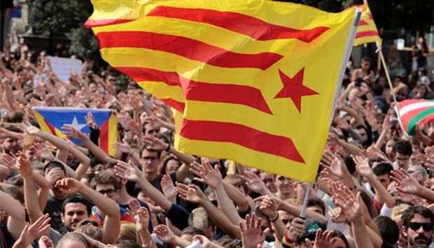 People shout as an Estelada (Catalan separatist flag) flutters during a protest the day after the banned independence referendum in Barcelona on Monday.