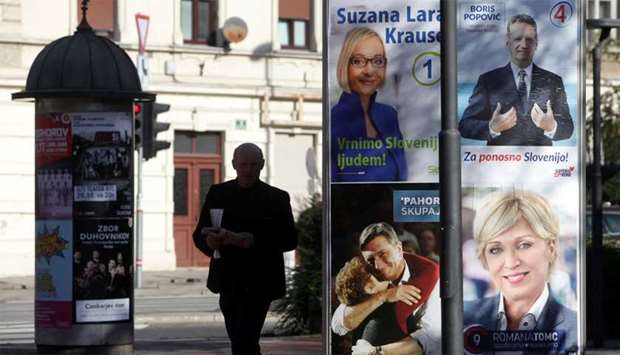 A man walks past presidential election campaign posters in Ljubljana