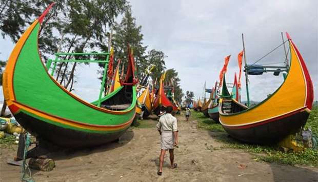 Bangladeshi fisherman walk near fishing boats at Maheshkali Pora island near Teknaf on Sunday.