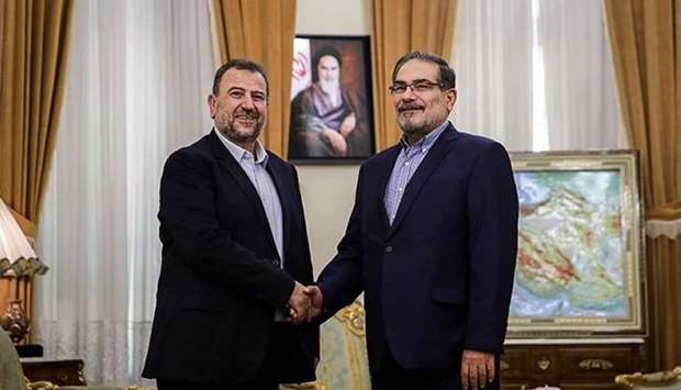 Saleh al-Arouri (L), Hamas deputy chief, shakes hands with Ali Shamkhani, secretary of Iran's National Security Council, during their meeting in Tehran, Iran yesterday