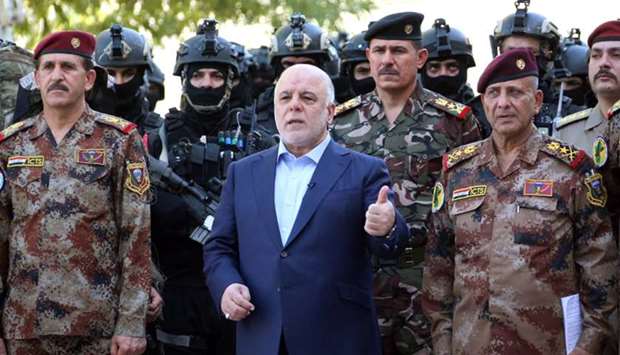 Haider al-Abadi (c) posing for a picture with army generals and members of the counter-terrorism forces in the capital Baghdad