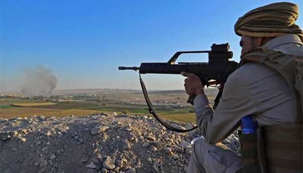 A Peshmerga fighter takes aim from his position at the Altun Kubri checkpoint, 40km from Kirkuk, on Friday. Iraqi forces clashed with Kurdish fighters as the central government said it wrestled back control of the last area of disputed Kirkuk province.