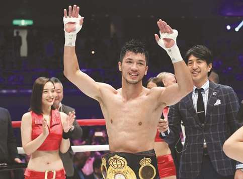 Ryota Murata of Japan (centre) raises his arms after his victory by technical knock-out against Hassan Nu2019Dam of France during the World Boxing Association (WBA) middleweight title bout in Tokyo yesterday. (AFP)