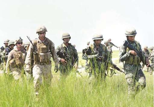 File photo shows Philippine marines (in green) and their US counterparts (in light brown) after simulating an assault during the annual Philippines-US amphibious landing exercise (Phiblex) at the navy base facing the South China Sea in San Antonio, Zambales province, north of Manila.