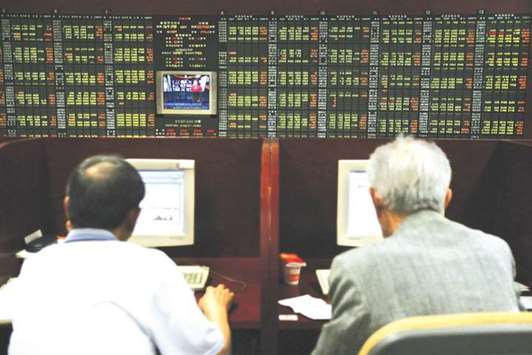 Traders look at a stock index board in Seoul. Investors are growing more bullish on riskier Korean firms amid expectations that the expanding economy and exports will boost their earnings.