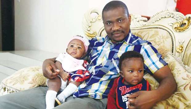 Kelly Chuunga, whose wife died after giving birth in Lusaka six months prior, poses with his twins Karen and Kelly junior at their grandmotheru2019s house in Lusaka.