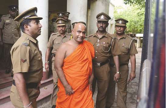 Police escort Buddhist monk Akmeemana Dayarathana, centre, after he was remanded in custody in Colombo yesterday, over his involvement in a violent attack on Rohingya refugees.