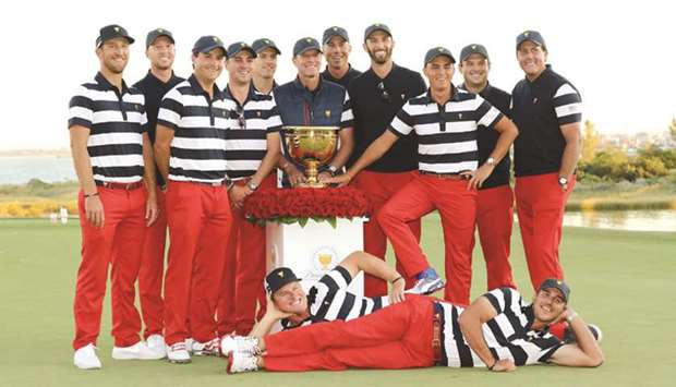 The United States team celebrate with the trophy after they defeated the International Team 19 to 11 in the Presidents Cup at Liberty National Golf Club in Jersey City, New Jersey, on Sunday. (AFP)