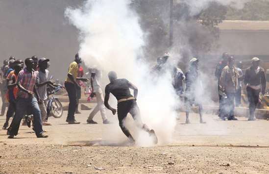 Protesters react to teargas fired by riot policemen during a protest in Kisumu, Kenya.