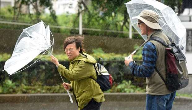 A woman have an umbrella turned inside out with strong wind in Tokyo