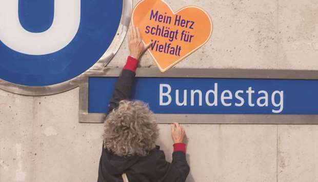 A woman holds a sign reading u2018My heart beats for diversityu2019 at the Berlin subway station u2018Bundestagu2019, during a march against the AfD party.