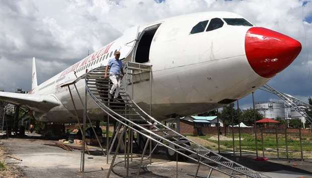 Nepali pilot Bed Upreti walks from an airplane that has been converted into an aviation museum in Ka