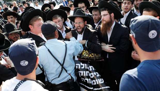 Israeli police stand guard as Ultra-Orthodox Jews demonstrate against Israeli army conscription outside the Knesset (Israeli parliament) in Jerusalem
