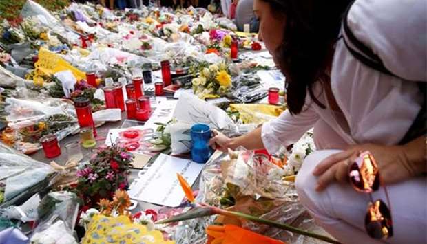 People place flowers at a memorial for murdered investigative journalist Daphne Caruana Galizia in Valletta.