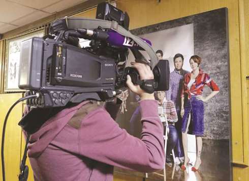A cameraman records a photograph showing the employees of Russian radio station Ekho Moskvy, including anchor Tatyana Felgengauer (right, in red).