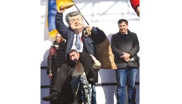 Saakashvili (R) smiles during a performance by an activist wearing a mask depicting President Poroshenko during a rally on Sunday in front of the Ukrainian parliament in Kiev.