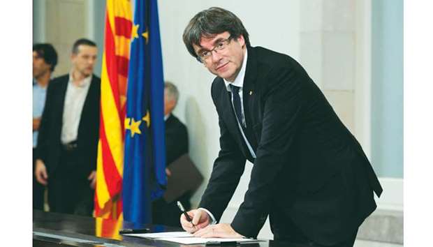 Catalan regional government president Carles Puigdemont signs a document about  the independence of Catalonia at the Catalan regional parliament in Barcelona on October 10. Puigdemont said he accepted the u201cmandate of the peopleu201d for the region to become u201can independent republic,u201d but proposed suspending its immediate implementation to allow for dialogue.