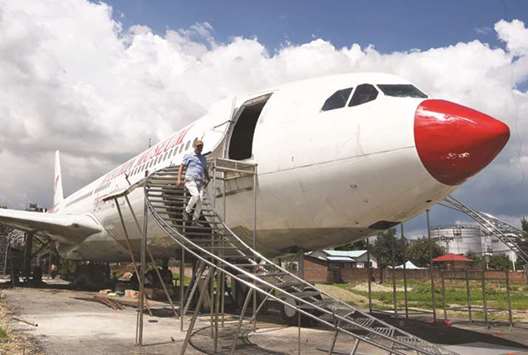 Nepali pilot Bed Upreti walks from an airplane that has been converted into an aviation museum in Kathmandu.