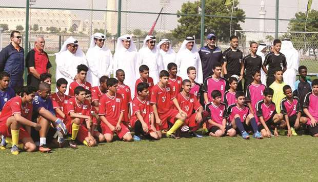 Officials pose with children during the launch of the 11th edition of the Schools Olympic Program at the Qatar Sports Club on Sunday.