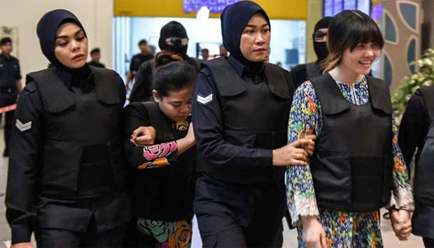 Vietnamese defendant Doan Thi Huong (R) and Indonesian defendant Siti Aishah (2nd, L) are escorted by police personnel at the Kuala Lumpur International Airport 2 (KLIA2) 