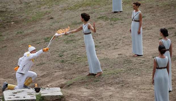 Greek actress Katerina Lehou, playing the role of High Priestess passes the flame to Greek cross country skiing athlete Apostolos Aggelis during the Olympic flame lighting ceremony for the Pyeongchang 2018 Winter Olympics
