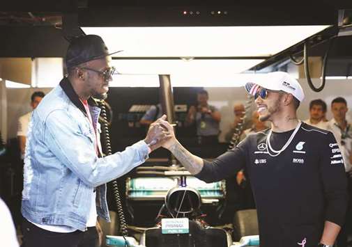 Sprinting legend Usain Bolt (left) shakes hand with Lewis Hamilton of Great Britain and Mercedes GP in the Mercedes F1 garage before the United States Formula One Grand Prix at Circuit of The Americas on October 22, 2017 in Austin, Texas. (AFP)