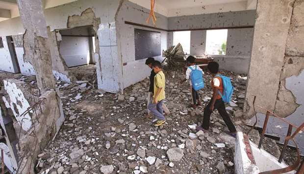 Boys walk in their school damaged by a recent Saudi-led air strike, in the Red Sea port city of Hodeidah, yesterday.