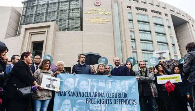 Protesters hold a banner that reads, ,Free rights defenders, during a rally outside the court house where the trial of eleven human rights activists is taking place in Istanbul 