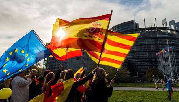 Women hold Spanish, Catalan and European flags during a demonstration against Catalonia's independence