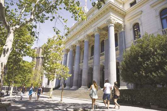 Pedestrians pass the Madrid Stock Exchange. The IBEX 35 closed 1.9% up at 10,347.8 points yesterday.