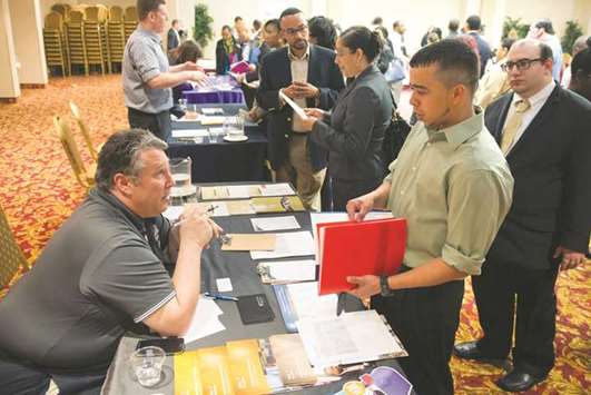 A recruitment official talks to a job seeker at a career fair in New York (file). Initial claims for state unemployment benefits increased 10,000 to a seasonally adjusted 233,000 for the week ended October 21, the Labour Department said yesterday.