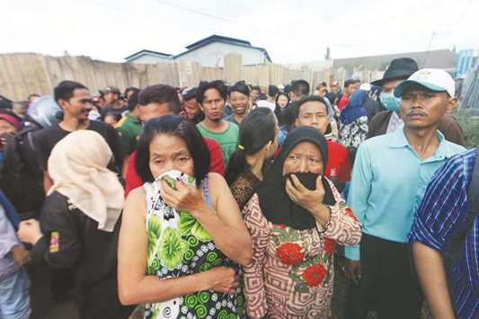 Indonesian people look at a firecracker factory that burned down in Tangerang Kota, Banten province yesterday.