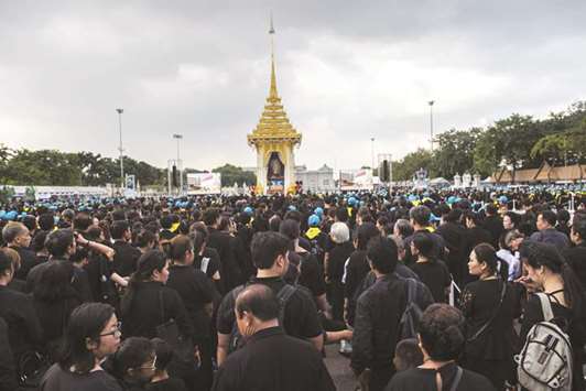 Mourners wait to offer flowers as a sign of respect for the late Thai king Bhumibol Adulyadej at the King Rama V Monument in Bangkok.