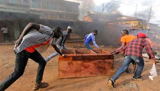 Rioters push a cupboard in Kawangware slums in Nairobi on Friday.