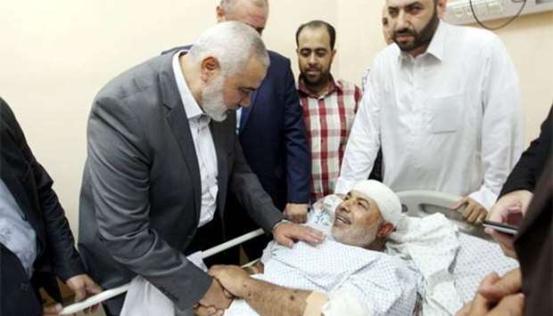 Hamas chief Ismail Haniyeh visits Hamas's security chief Tawfeeq Abu Naeem, as he lies on a hospital bed in Gaza City on Friday.