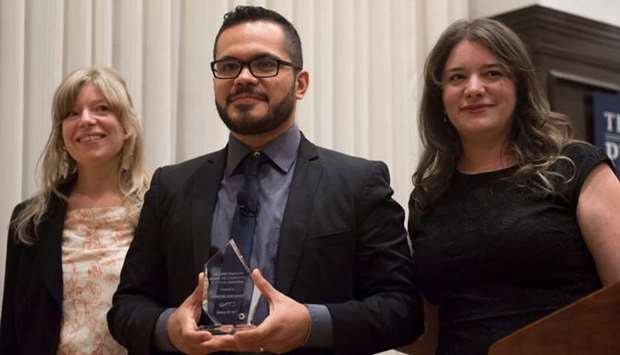 Marcos Vizcarra, a journalist for the Mexican publication Noroeste, receives the the 2017 Peter Mackler Award from Mackler's daughters, Camille (R) and Lauren (L), at the National Press Club in Washington, DC