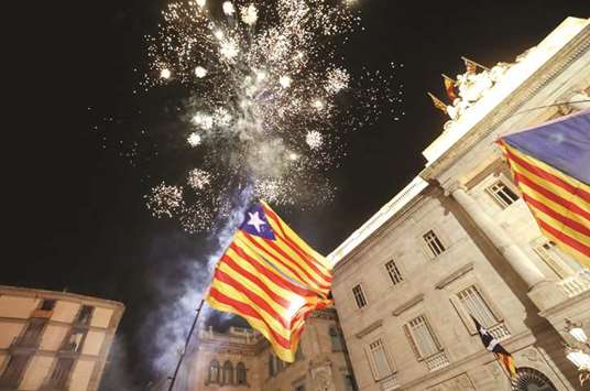 Catalan separatist flags are held up as fireworks go off in Sant Jaume Square in front of the Catalan regional government headquarters during celebrations after the Catalan regional parliament declared independence from Spain in Barcelona yesterday.