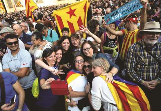 A group of people in front of the Catalan regional government headquarters in Barcelona take a selfie to mark the moment that the regional parliament declared independence from Spain.