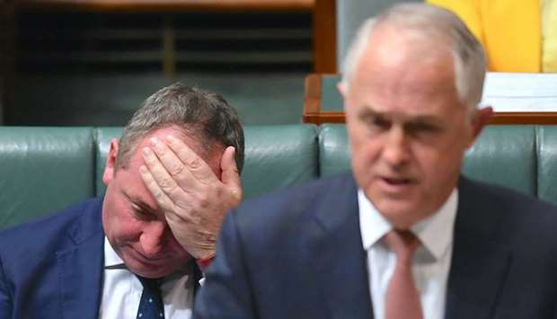 Australian Deputy Prime Minister Barnaby Joyce reacts as he sits behind Australian Prime Minister Malcolm Turnbull in the House of Representatives at Parliament House in Canberra, Australia