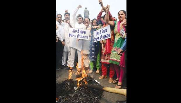 Activists of the Bharatiya Janata Party shout slogans as they burn an effigy depicting the Punjab government during a protest against the hike in electricity tariffs, in Amritsar yesterday.