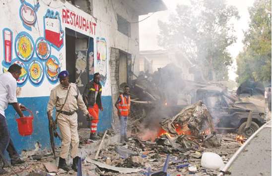 Somali security officers secure the scene of a suicide car bomb explosion at the Naso Hablod Two Hotel in the Hamarweyne district of Mogadishu.