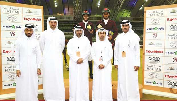 Officials pose with the winner of feature class, Hamad Nasser al-Qadi, and third-placed Saeed Nasser al-Qadi during the second leg of Hathab series at Al Shaqabu2019s indoor arena yesterday. PICTURES: Lotfi Garsi