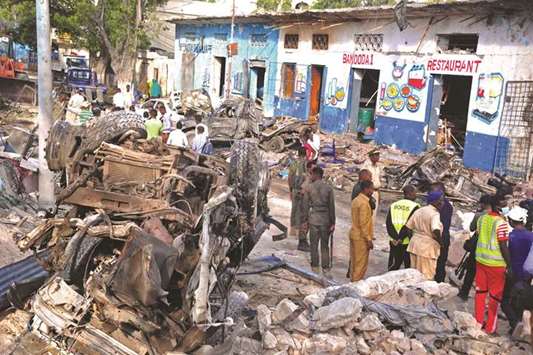 Local residents look at the scene of Saturdayu2019s car bomb blasts in Mogadishu yesterday.