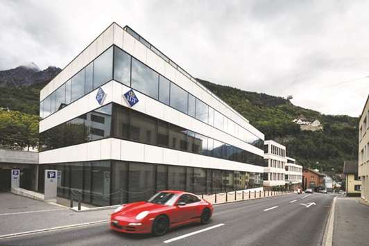 A Porsche luxury automobile passes the headquarters of LGT Group, Liechtensteinu2019s largest bank owned by the principalityu2019s ruling family, in Vaduz, Liechtenstein (file). LGTu2019s value has jumped 64% this year, more than quadruple the gain of the Euro Stoxx Banks Index, thanks in part to a 10% increase in net assets.