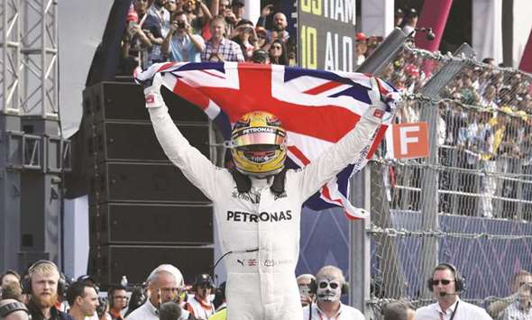Mercedesu2019 British driver Lewis Hamilton celebrates after winning his fourth Formula One world title despite finishing the Mexican Grand Prix in ninth place.