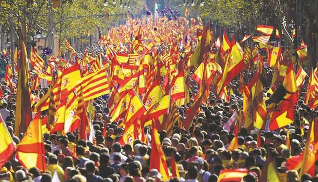 Protesters wave Spanish and Catalan Senyera flags during the pro-unity demonstration in Barcelona.