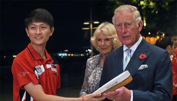 Prince Charles and Duchess of Cornwall Camilla receive the Queen's Commonwealth Baton from a Singaporean athlete in Singapore on Monday.
